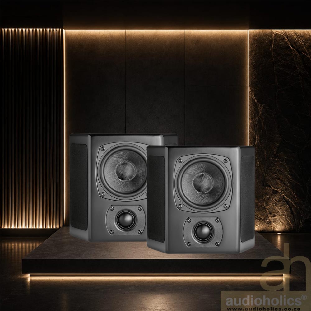 MK-M40T - Audioholics South Africa Two gray studio monitor speakers placed on a dark pedestal in a moody, upscale room with warm backlighting and a textured wall.