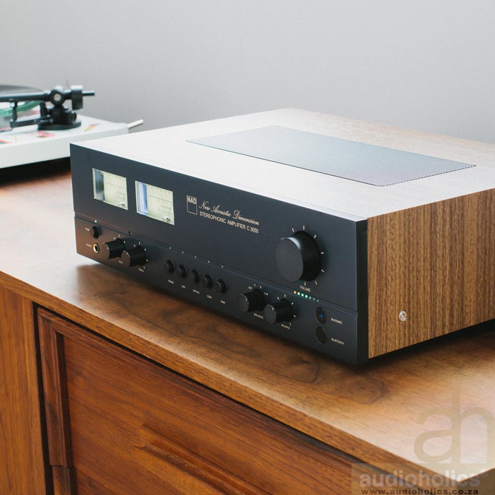 NAD-3050 - Audioholics South Africa Vintage NAD stereo amplifier with wood side panels on a wooden cabinet; two VU meters and multiple knobs on the front panel are visible.
