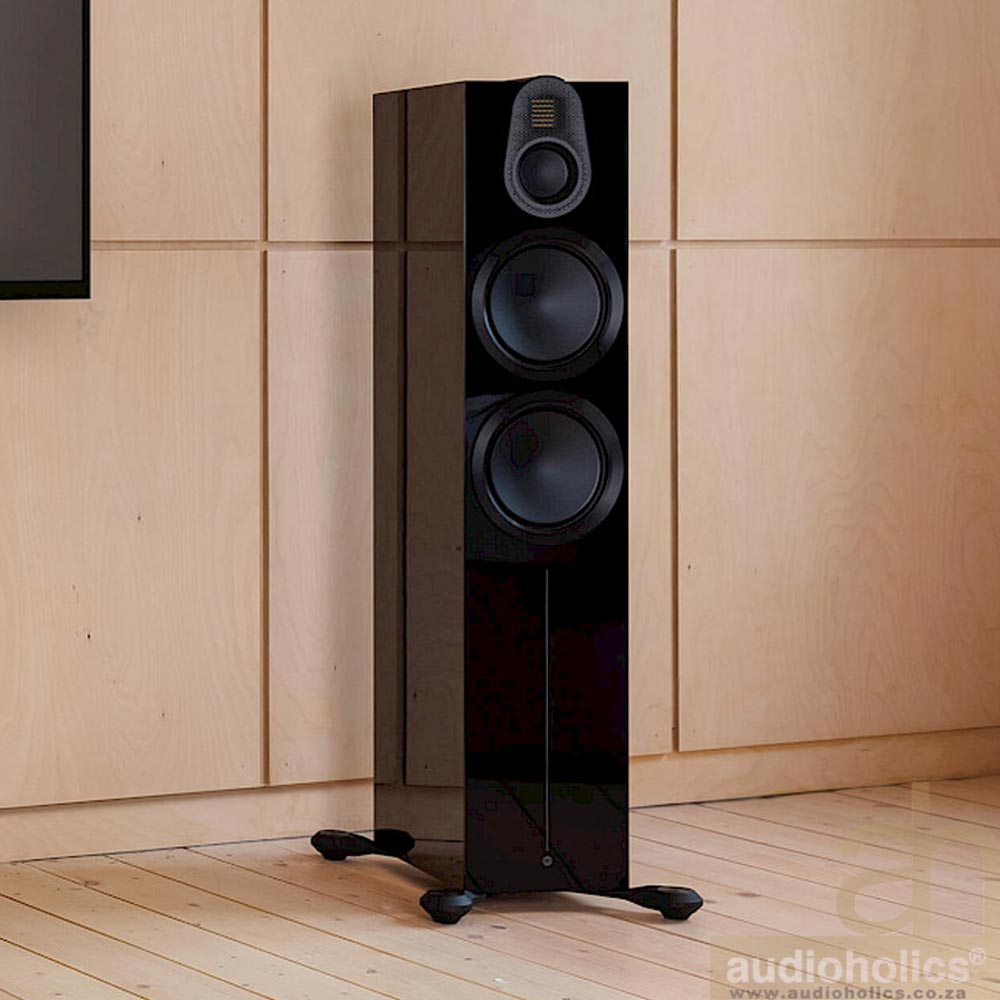 Monitor-Audio-Gold-500 - Audioholics South Africa Tall black floor-standing speaker with three drivers in a wooden room.