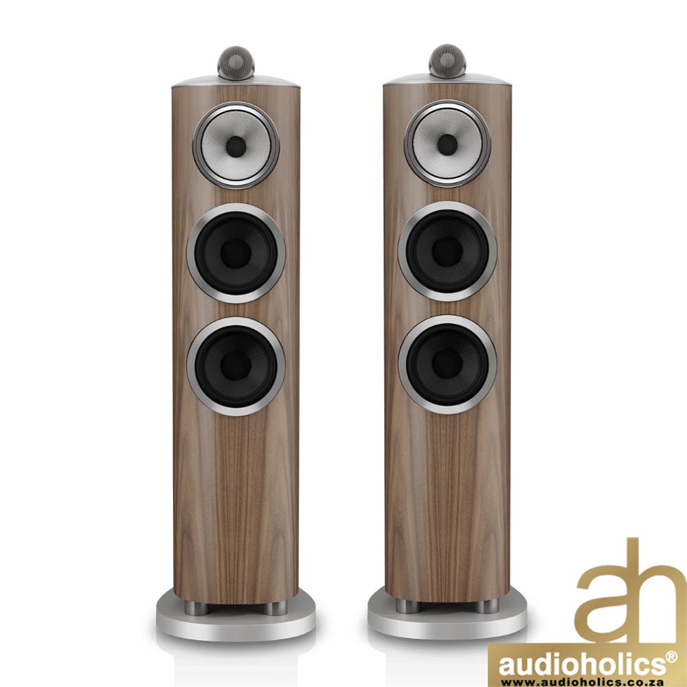 BW-804-D5-Galleryjpg-3 - Audioholics South Africa Pair of tall wooden floor-standing speakers with three drivers each and silver accents, on round metal bases; Audioholics logo bottom right.