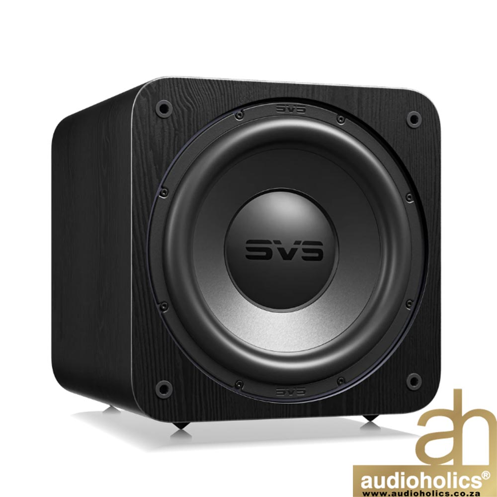 Black subwoofer with a large round driver and a wood-grain cabinet; Audioholics logo in the bottom-right corner.