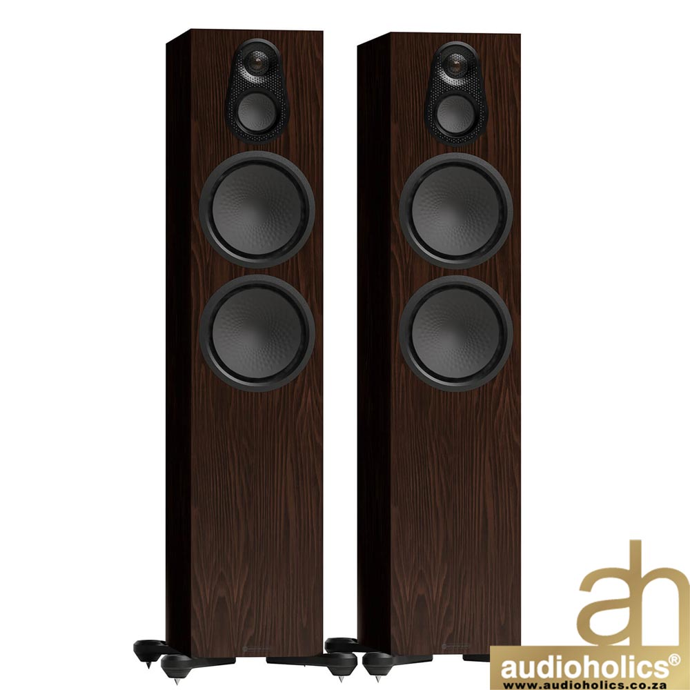 Monitor-Audio-Silver-500-Walnut - Audioholics South Africa Pair of tall floor-standing speakers with dark wood grain finish and multiple drivers, Audioholics logo bottom right.