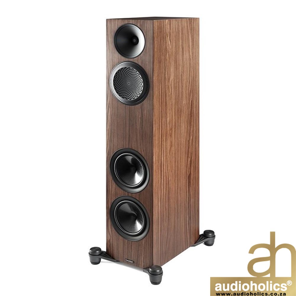 Tall floor-standing speaker with walnut wood veneer showing three visible drivers: a top tweeter, a midrange, and two bottom woofers; Audioholics logo corner right bottom.