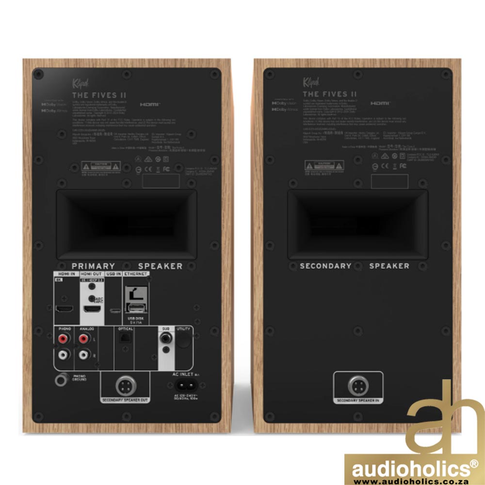 Klipsch-The-Fives-II-Main---Red-Oakjpg-4 - Audioholics South Africa Pair of wooden bookshelf speakers viewed from the back, showing labeled 'PRIMARY SPEAKER' and 'SECONDARY SPEAKER' panels with input ports and connectors; Audioholics watermark bottom-right.